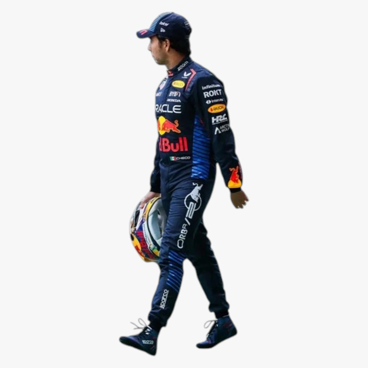 A racer in a dark blue Red Bull Racing suit walks while holding a colorful racing helmet, shown against a plain white background.