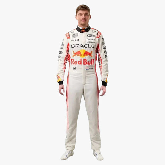 A man wearing a full Oracle Red Bull Racing driver's racing suit, standing against a solid light gray background. The suit is primarily off-white with red and black sponsor logos and stripes.