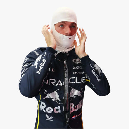 A man wearing a dark navy Red Bull Racing jacket with white sponsor logos, adjusting a white balaclava mask against a plain white background.