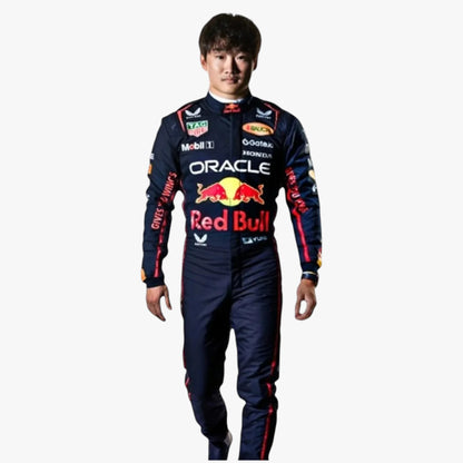A man wearing a dark navy Red Bull Racing team racing suit with prominent red, yellow, and white sponsor logos, standing against a plain light gray background.