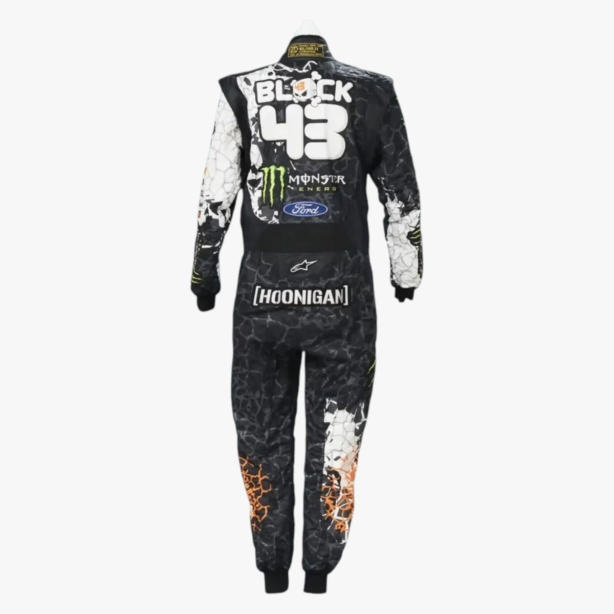 Racing suit shown from the back on a white background, featuring a black and white cracked pattern with orange flame details on the lower legs, and sponsor logos including Monster Energy, Ford, Alpinestars, and Hoonigan.