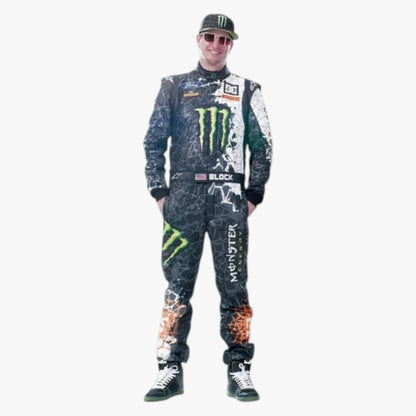A man modeling a full racing suit and matching cap against a plain white background. The suit is black with green Monster Energy logos, white graphics, and orange flame details on the legs.