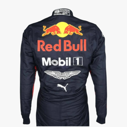 Back view of a Red Bull Racing team long-sleeve racing suit in navy blue, featuring large sponsor logos including Red Bull, Mobil 1, Aston Martin, Puma, and Castore on the back.