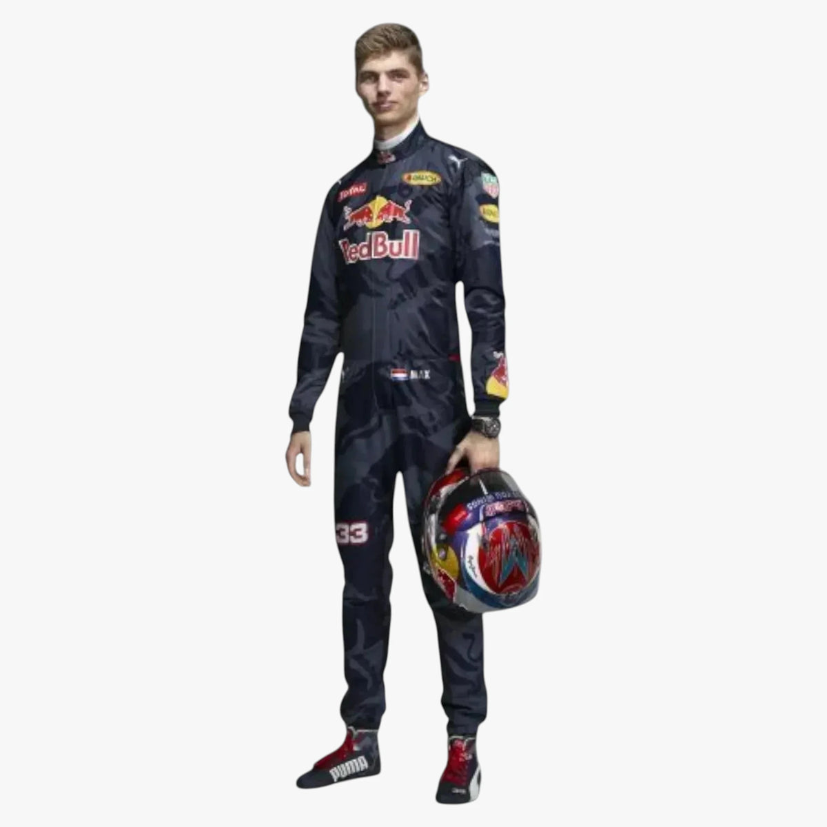 A man wearing a dark Red Bull racing suit and holding a Red Bull helmet, standing against a plain light gray background.