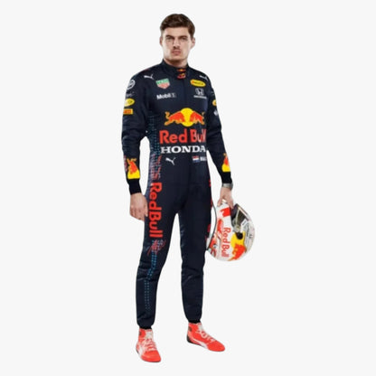 A full-body studio shot of a man wearing a Red Bull Racing Honda racing suit and holding a matching Red Bull helmet, set against a plain white background.